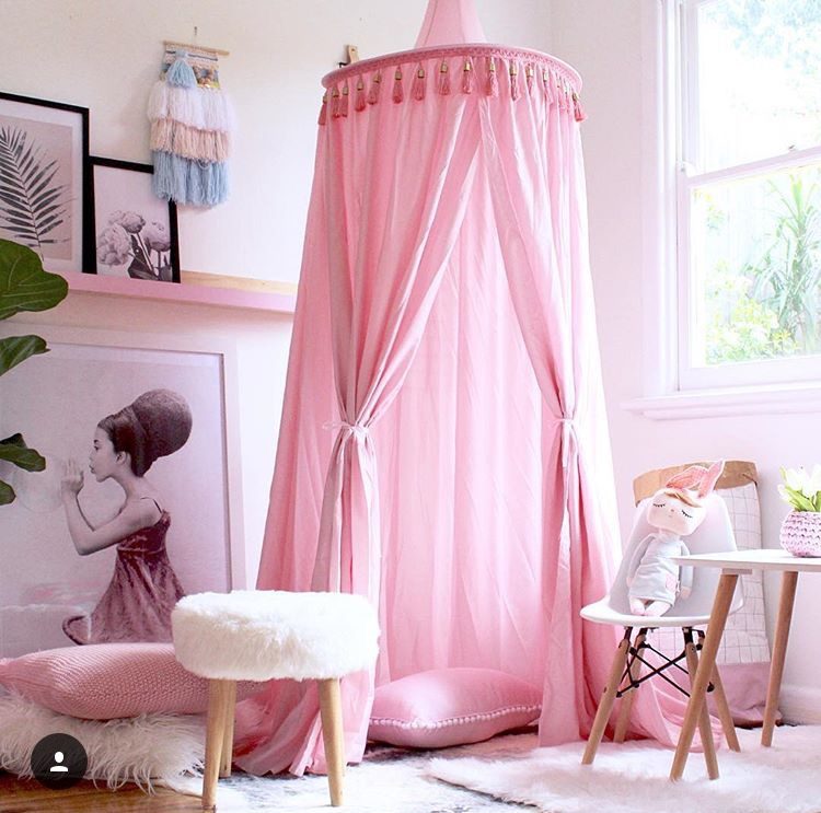 Pink canopy in girls bedroom of colourful home