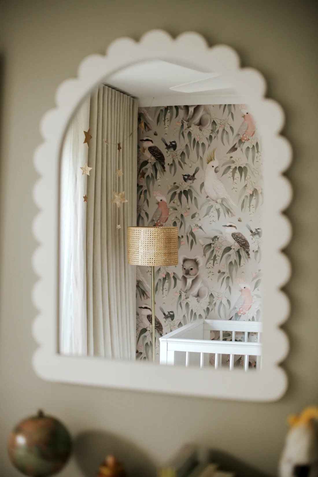 White scalloped mirror reflecting Australian animal wallpaper