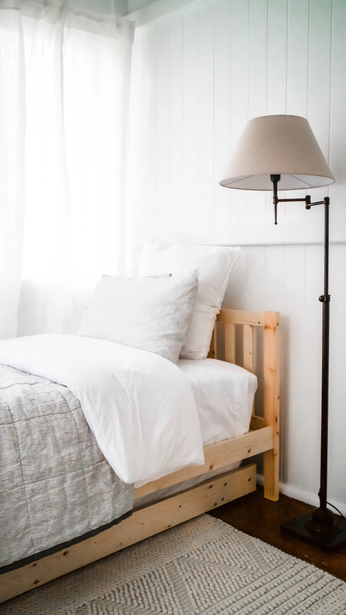 Summerholm House guest bedroom with neutral bedding and floor lamp