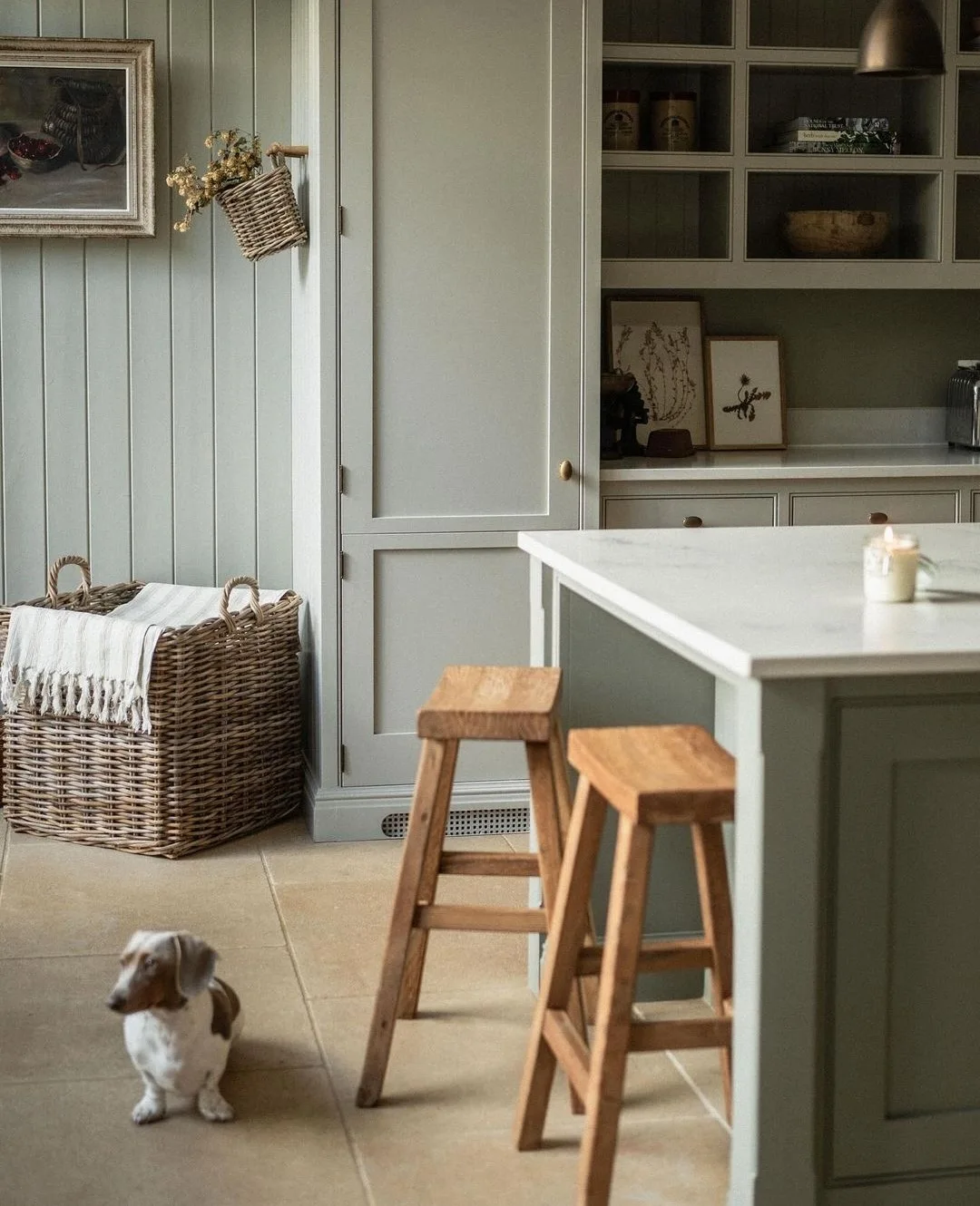 Pale green kitchen cabinetry and panelling in English kitchen