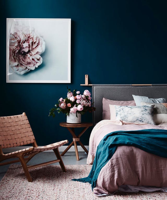 Dusty pink bedding and dark blue wall