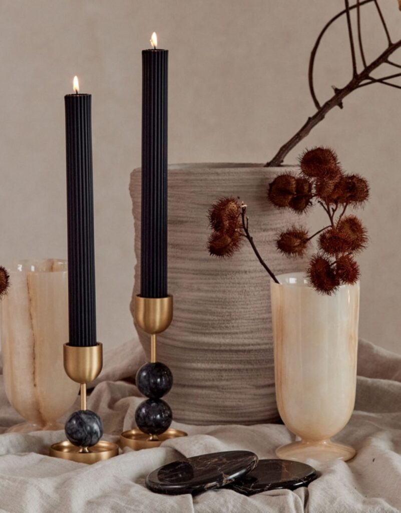 Black ribbed taper candles in brass holders