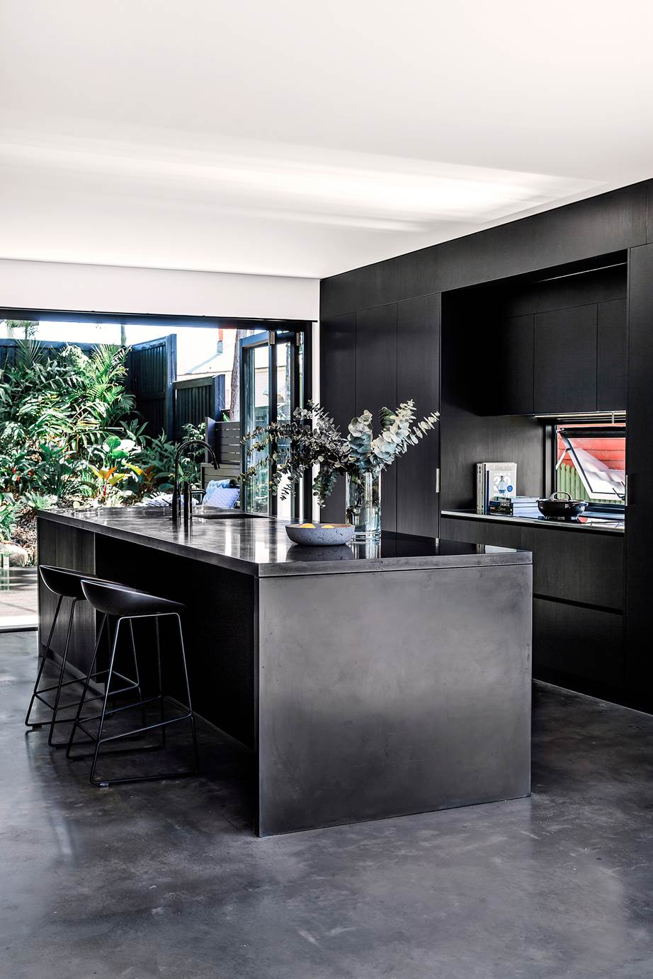 Black kitchen on polished black concrete floor