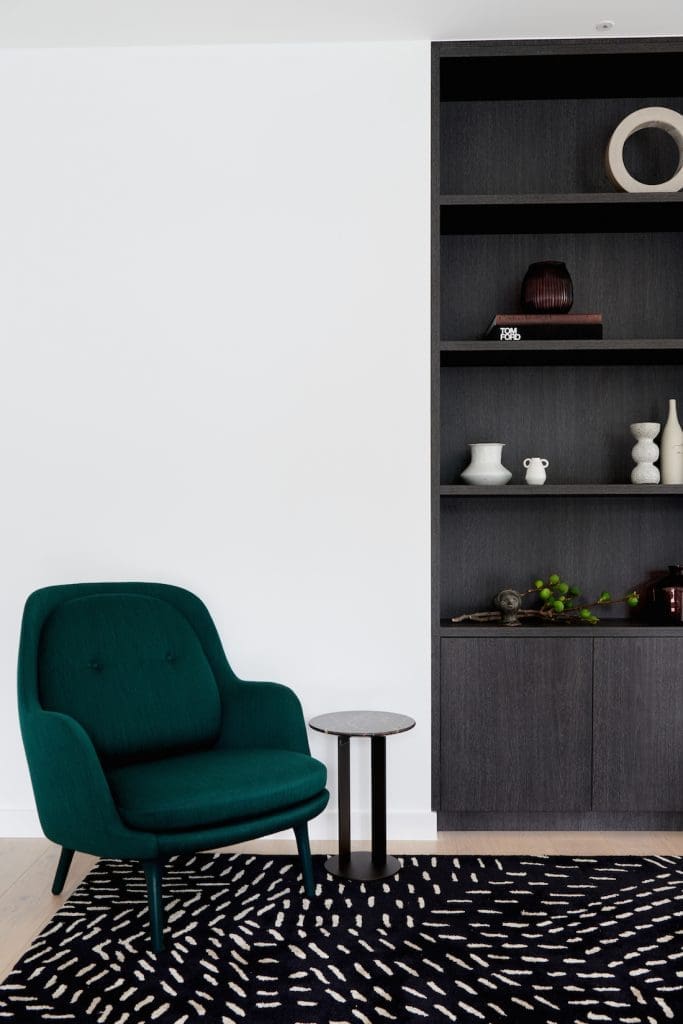 Alexi George styling lounge room with green velvet chair and bookcase in this modern home