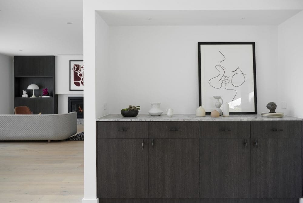 Dark veneer built in cupboards with stone top and view to lounge