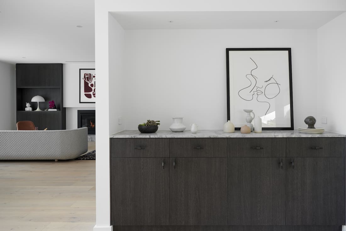 Dark veneer built in cupboards with stone top and view to lounge joinery perfection