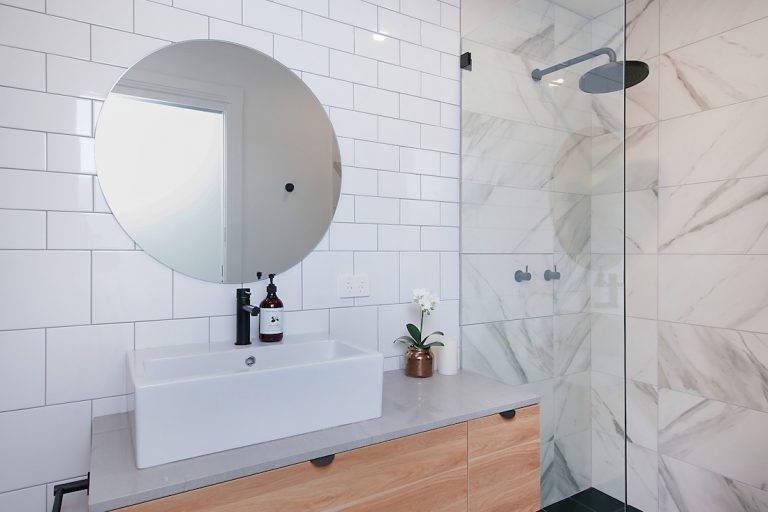White bathroom with statement round mirror