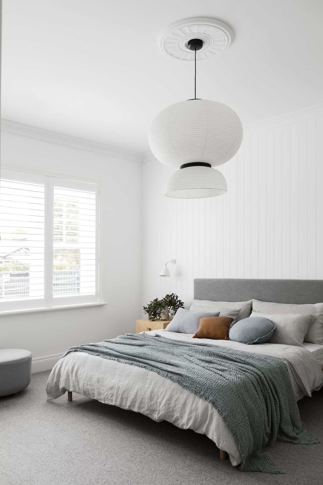 White panelled wall bedroom with statement light