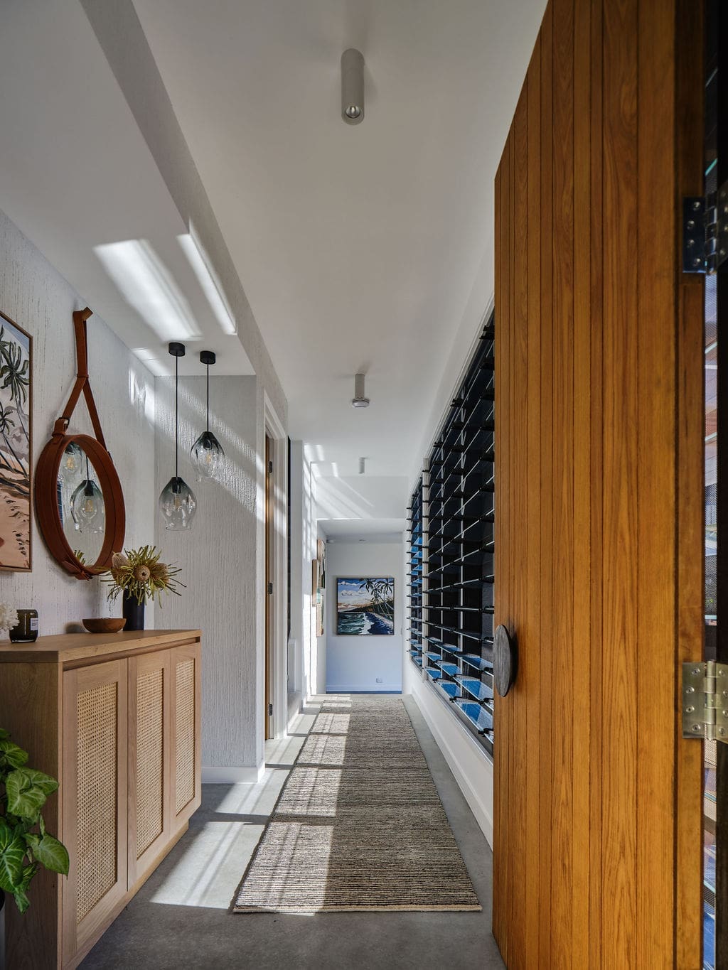 Hallway with louvers and glass pendant lighting