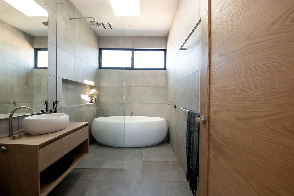 Large white freestanding bath in neutral bathroom