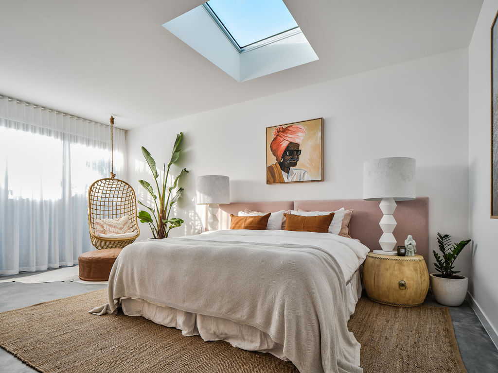 Neutral bedroom with hanging chair and skylight