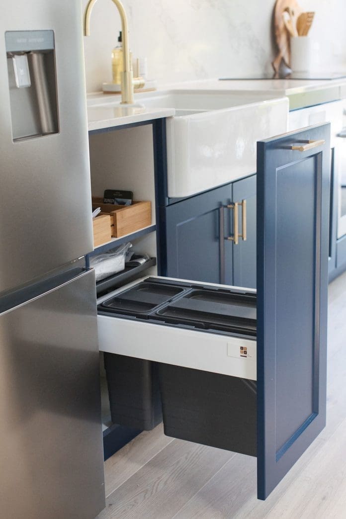 Navy blue kitchen with luxe brass accents and marble look benchtop
