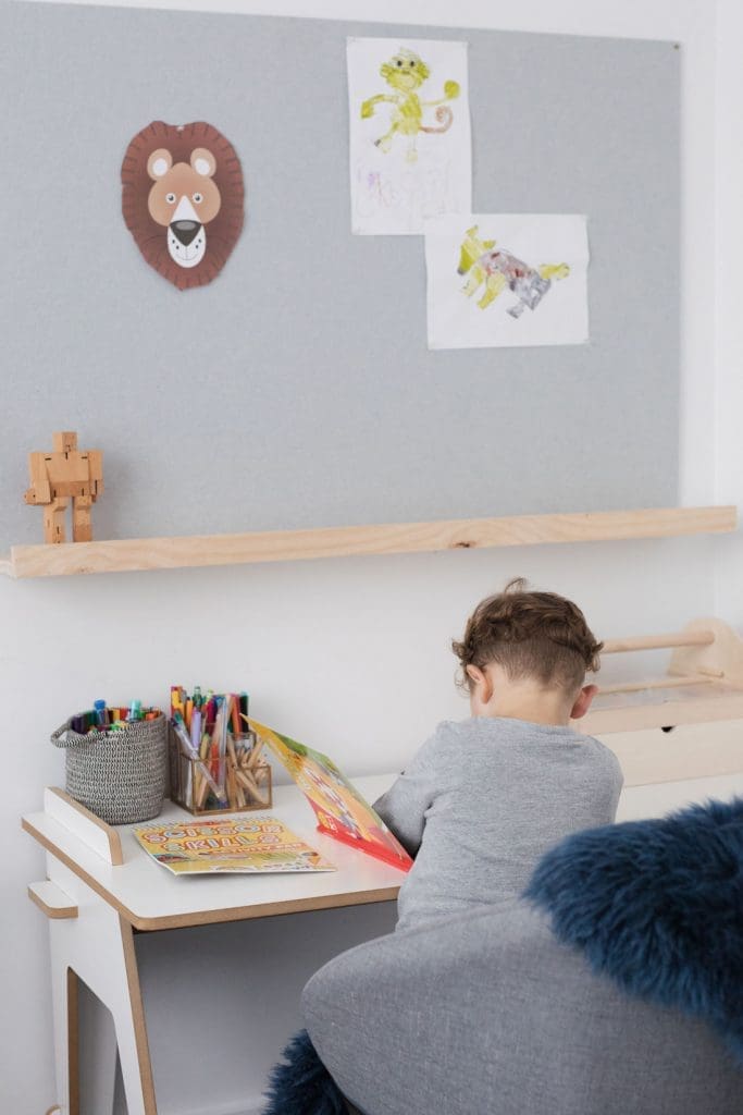 Patrick working at his desk with DIY oversized pinboard