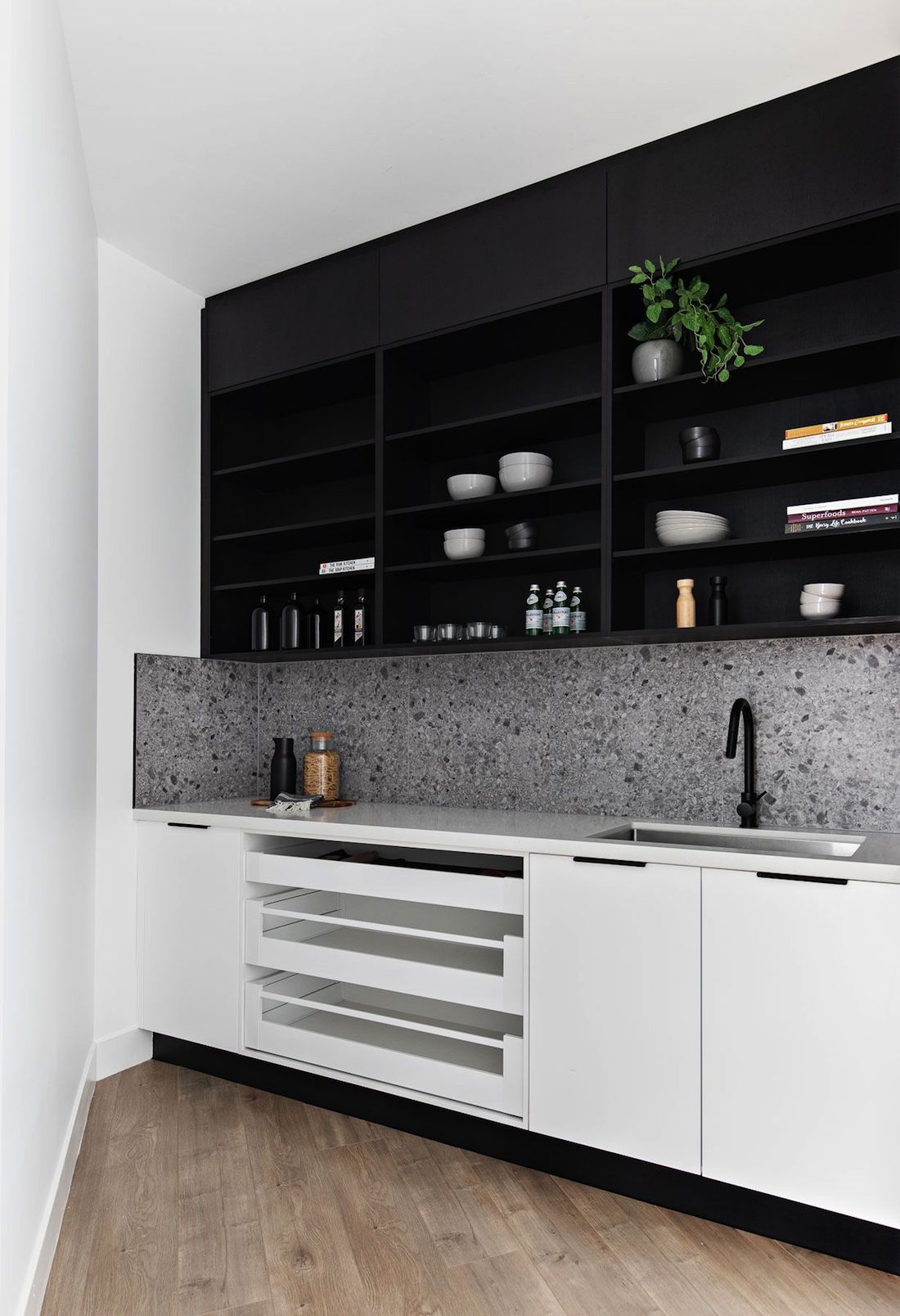 Black kitchen with open shelving and white cabinetry