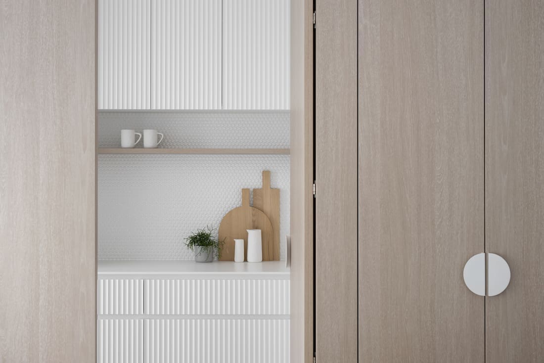 Timber doors in scalloped edged draws and penny tile pantry