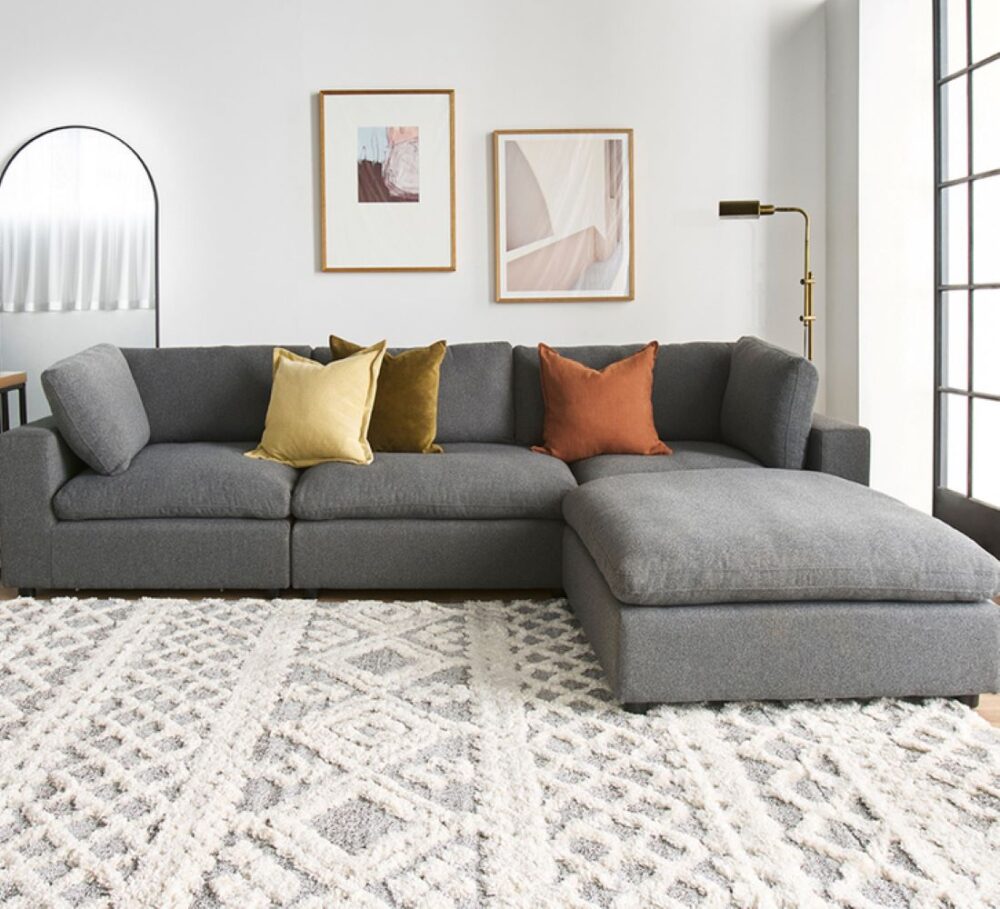 Harmony 3 Seater Charcoal Chaise Sofa featuring deep cushions, a spacious chaise, charcoal fabric upholstery and a contemporary modular design.
