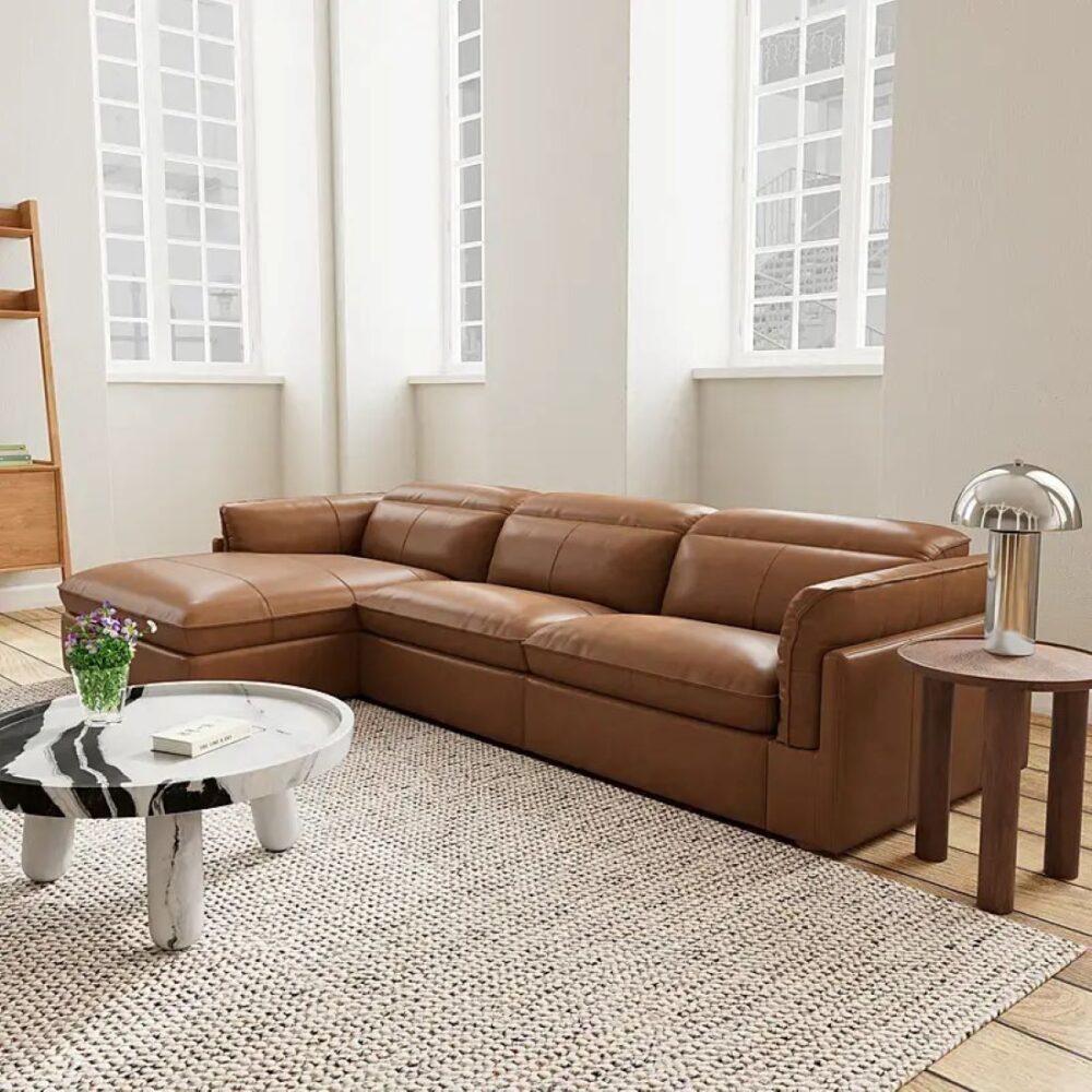 Tan leather left chaise sofa featuring deep seat cushions, wide armrests and a contemporary low-profile design.