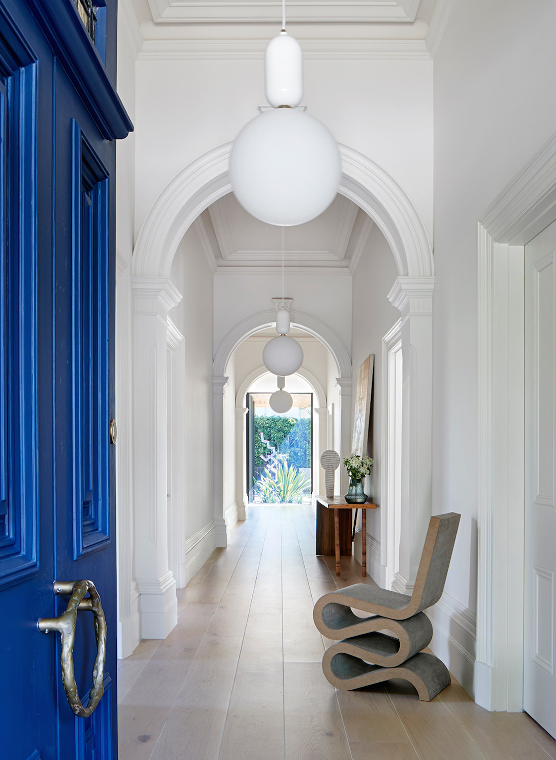 Coloured door into traditional white hallway