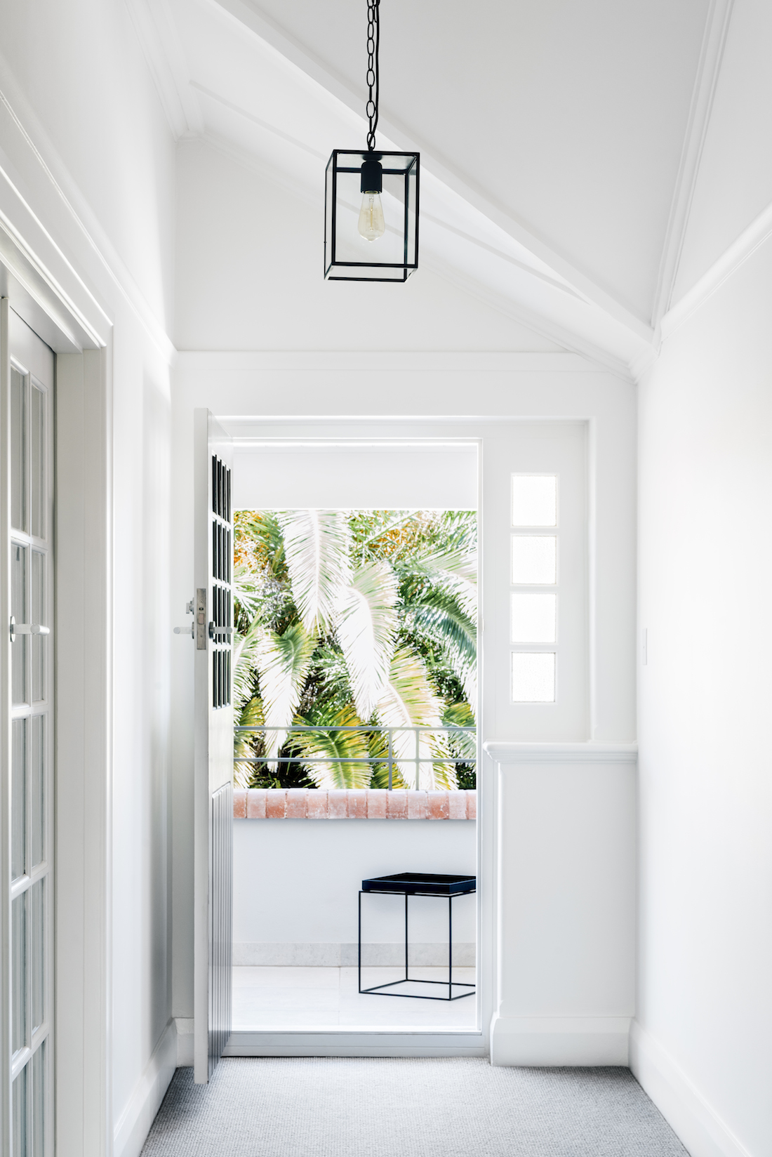 White and bright entrance to the home with black pendant light