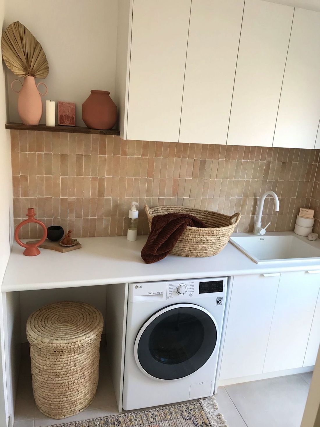 Stylish laundry with pink feature tile