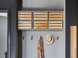 Grey mudroom with wooden boxes for storage in garage and wooden height chart