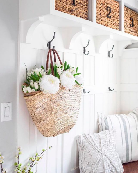 White mudroom with hooks and baskets for storage
