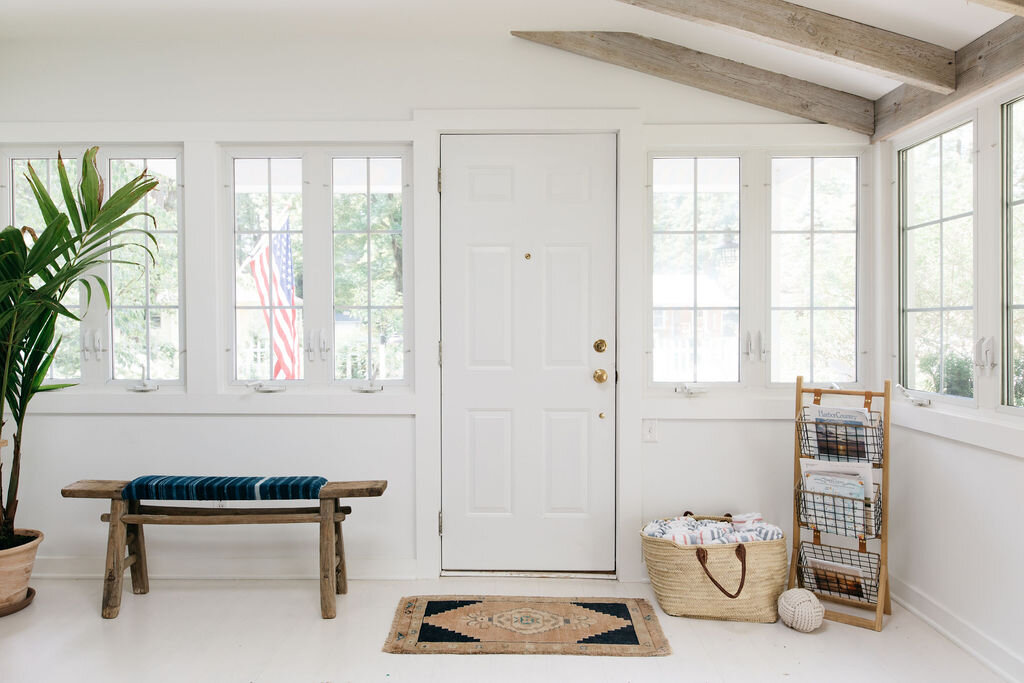 Drop zone by door of white home with rustic features