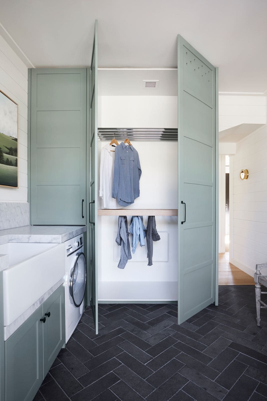 Green cabinetry in laundry mudroom room