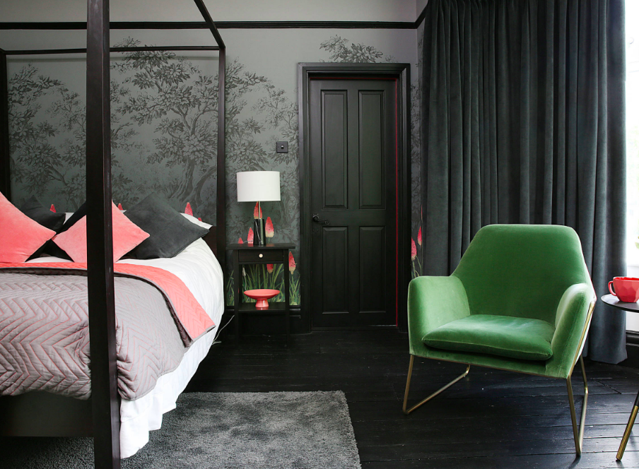 Eclectic bedroom with wallpaper and black floors