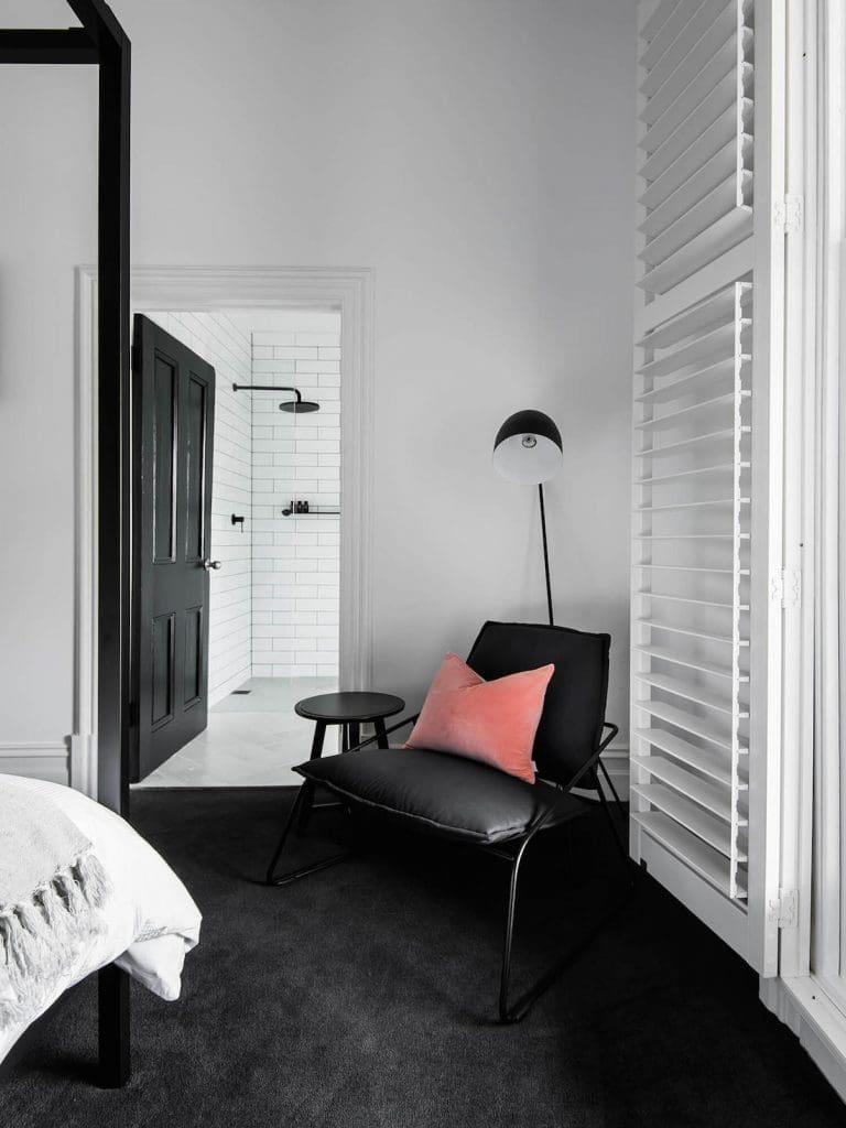 Black carpet in bedroom with four poster bed