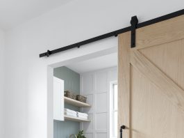 Laundry with panelling, green wall and sliding barn door