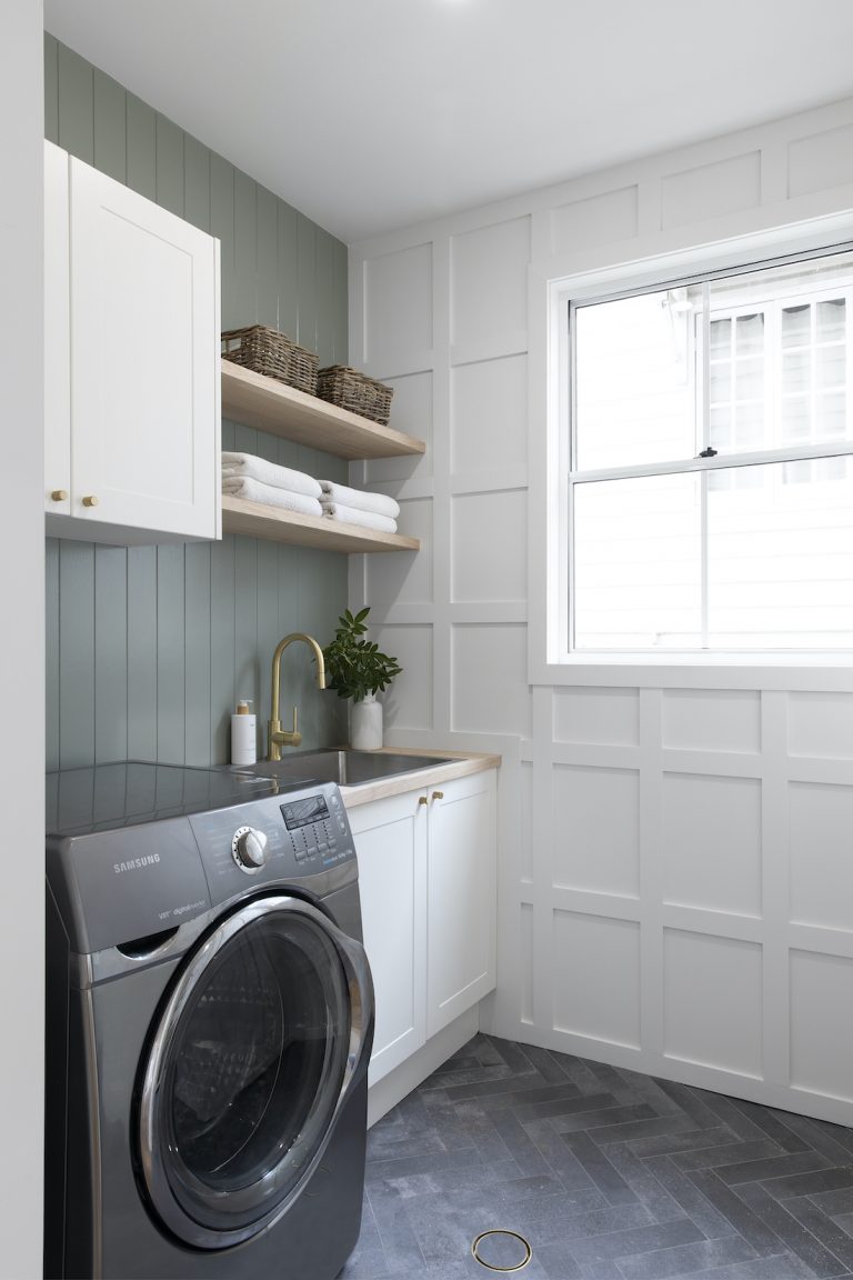 Small but stylish laundry with herringbone floor and barn door