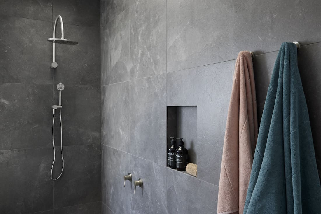 Dark tiled shower with shower niche