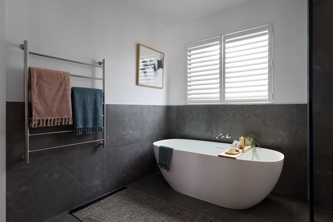 Large freestanding bath in dark toned bathroom