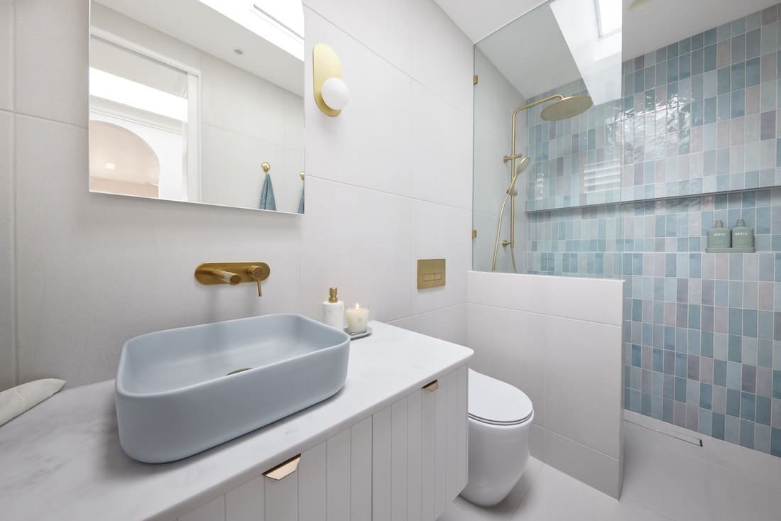 Blue tiled shower in bathroom