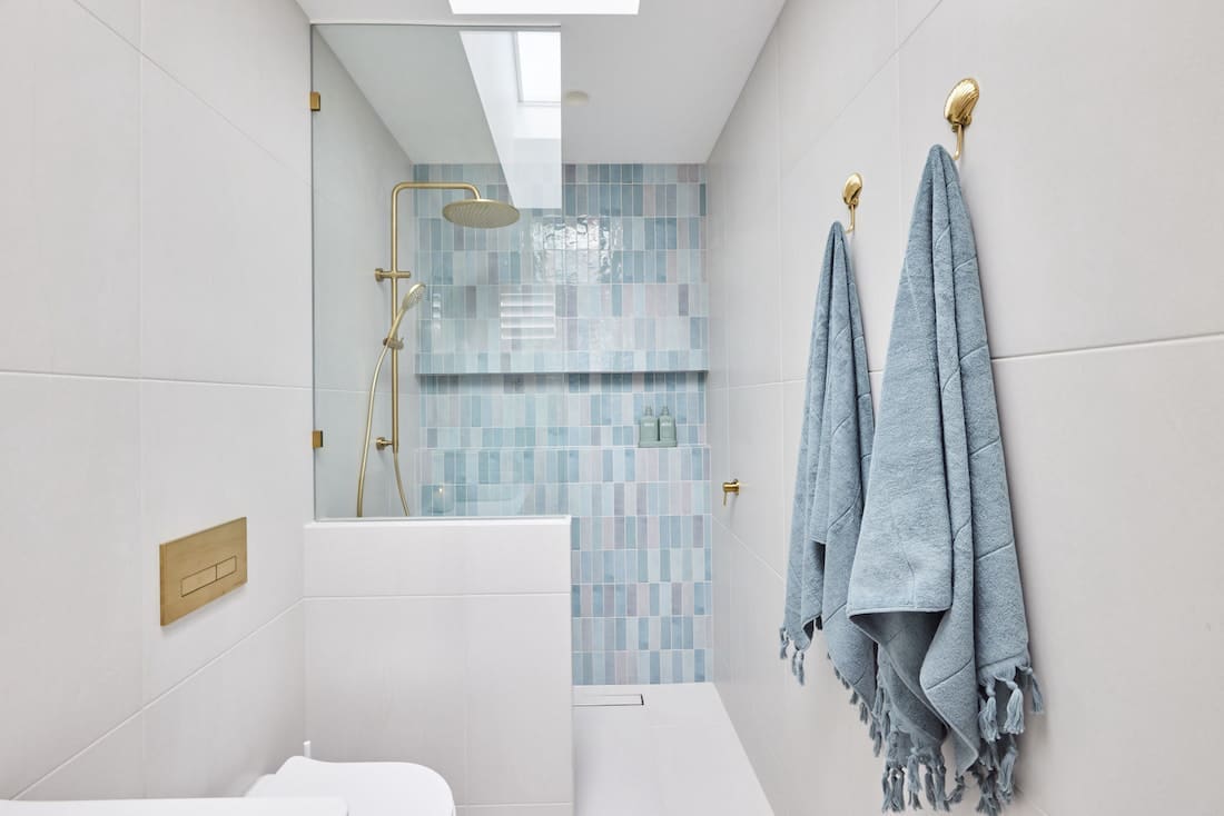 Blue tiled shower in ensuite bathroom