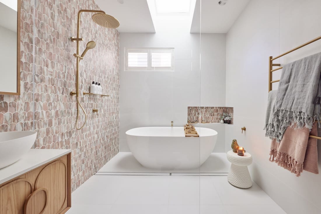 Pink and white bathroom with aged brass accents