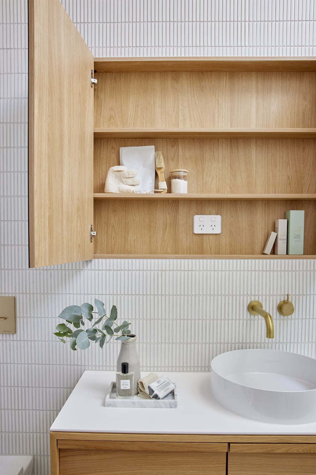 Timber storage unit behind mirror in bathroom