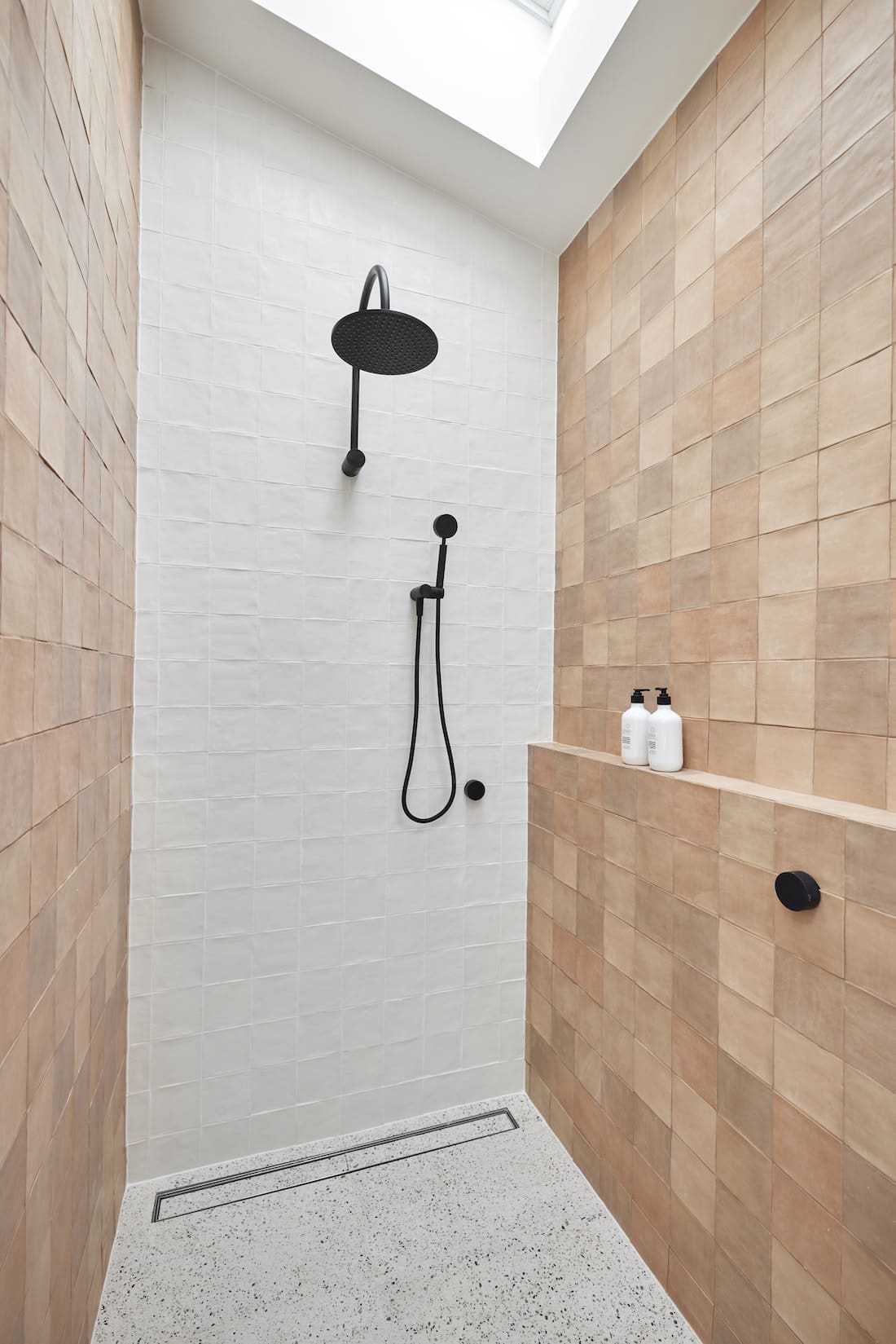 Black rain shower in white and brown shower with skylight