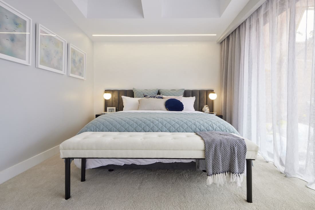 Master bedroom with blue throw on bed