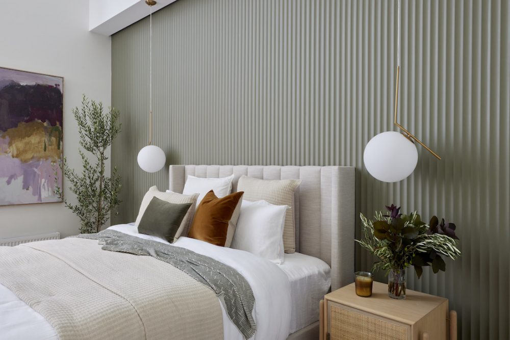 Master bedroom with sage green fluted feature wall