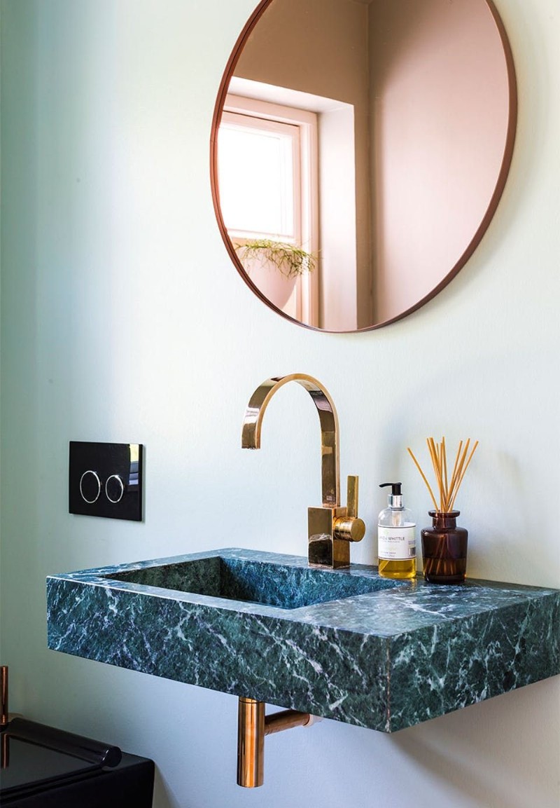 Rose gold round mirror with green marble sink
