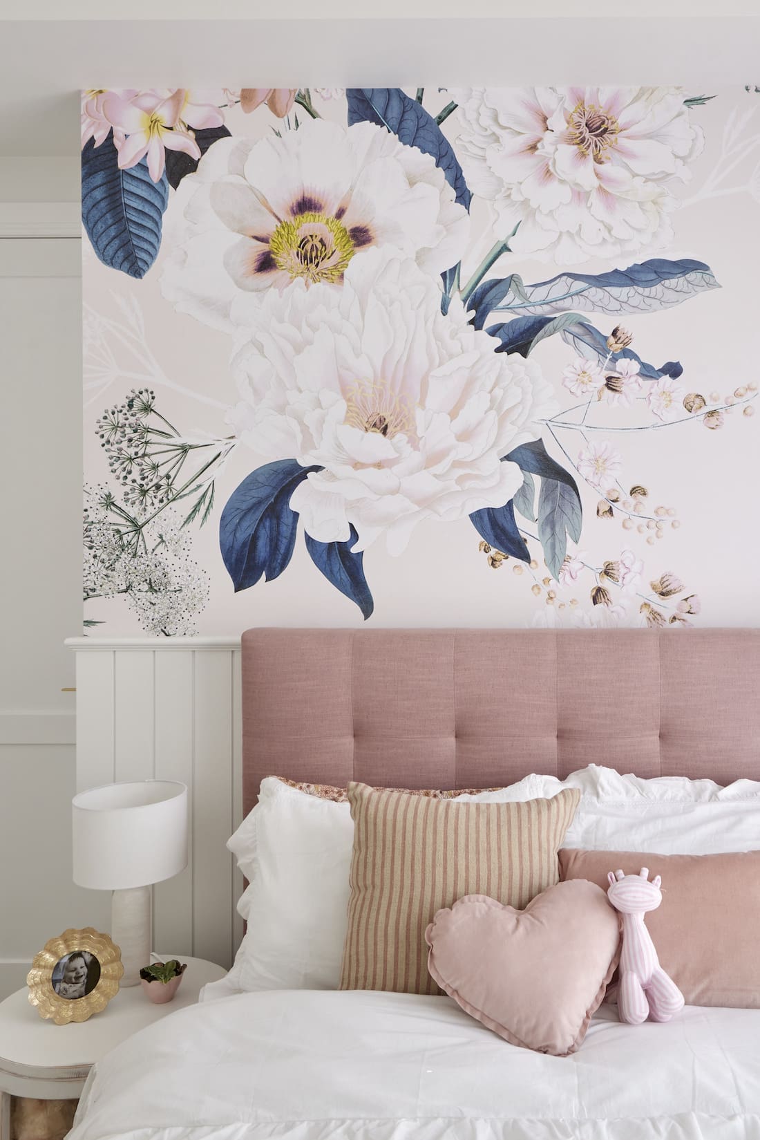 Pink padded be with floral wallpaper