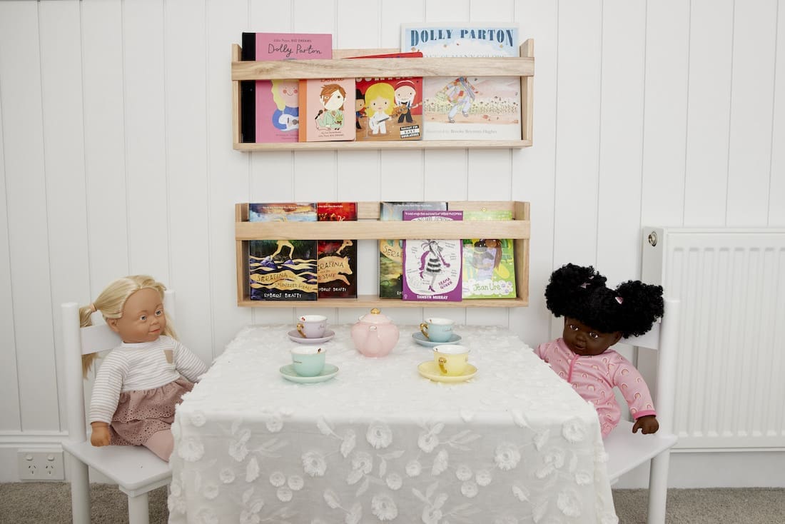 Bookshelf with dolls in kids bedroom