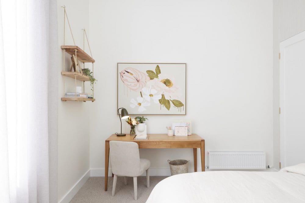 Desk space in bedroom with floral artwork