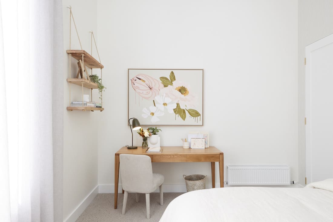 Desk space in bedroom with floral artwork