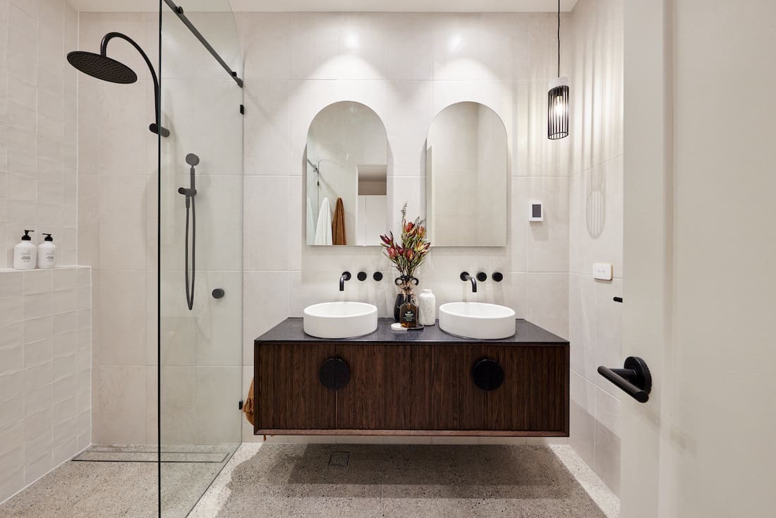 Dark timber vanity with arch mirrors