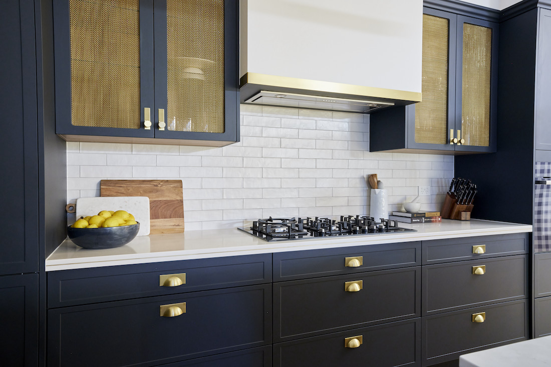 Navy cabinetry with brass insets