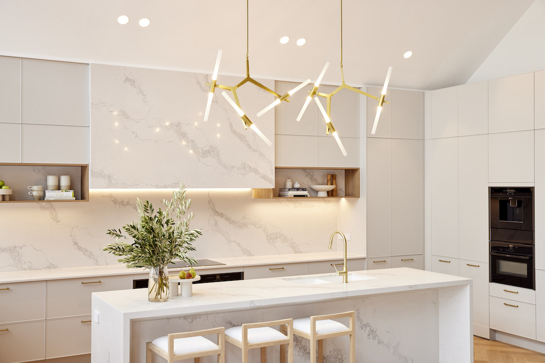 White stone kitchen with gold bar chandelier