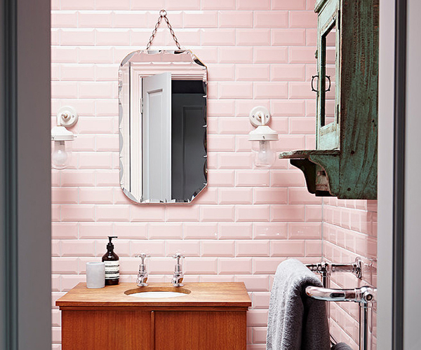 Pink tiled bathroom with vintage vanity and ornate mirror